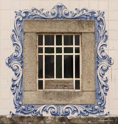 a blue and white window on the side of a building with an ornate frame around it