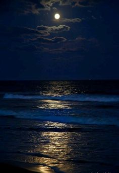 the moon is setting over the ocean with waves