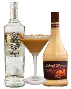 a bottle of liquor next to a glass filled with an alcoholic drink and a pumpkin pie