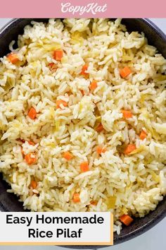 a bowl filled with rice and carrots on top of a table