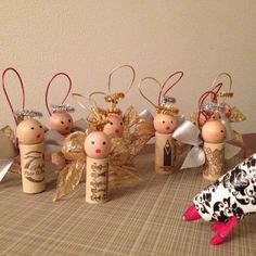 some wine cork angel ornaments are on a table