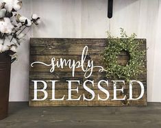 a wooden sign sitting on top of a shelf next to a vase filled with flowers