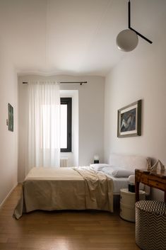 a bedroom with white walls and wooden floors