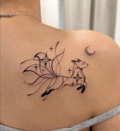 a woman with a tattoo on her shoulder that has a deer and stars in it