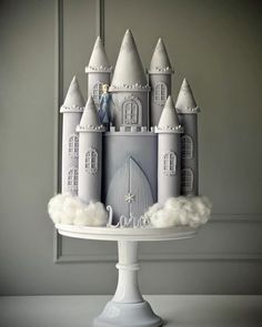 a cake that is shaped like a castle on top of a white plate with clouds around it