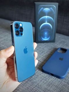 a person holding an iphone in their hand next to a box with speakers on it