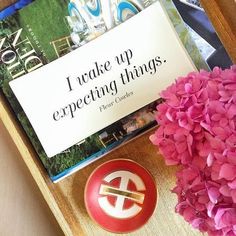 a wooden tray topped with pink flowers next to a sign that says i make up expecting things