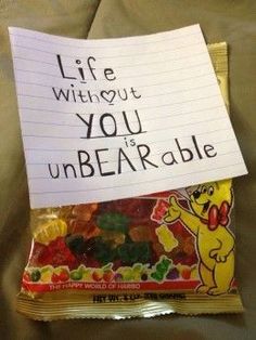 a bag of gummy bears sitting on top of a bed next to a sign