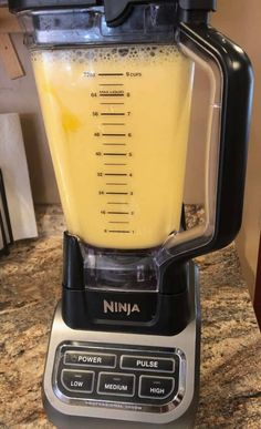 a blender filled with yellow liquid on top of a counter