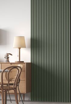 a room with a table, chair and lamp next to a green vertical striped wall