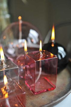 three candles are sitting on a tray with some glass cubes in front of them