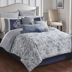 a bed with blue and white comforters in a bedroom