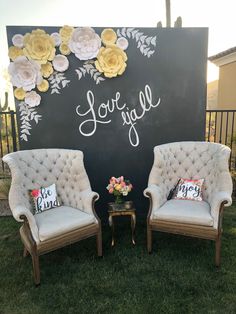 two chairs sitting next to each other in front of a sign that says love you