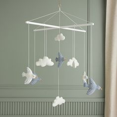 a baby crib mobile with doves and clouds hanging from it