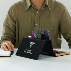 a person sitting at a desk with a book and pen holder in front of them