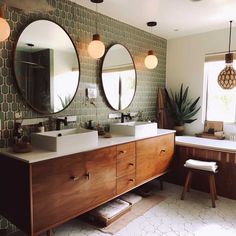 a bathroom with two sinks and three mirrors