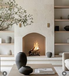 a living room filled with furniture and a fire place in the middle of a fireplace