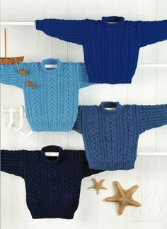 three sweaters and two starfish on a white background, one is blue the other is brown