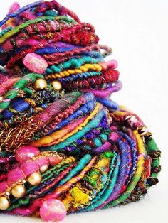 a pile of colorful bracelets sitting on top of a white table next to each other