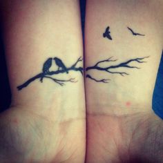 two birds sitting on top of each other's wrist tattoos