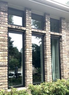 a cat sitting in the window of a brick building