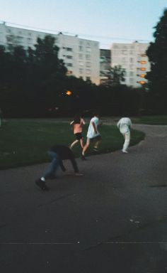 some people are playing with a frisbee in the park at night time,