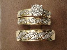 two gold wedding rings with diamonds on each one and an engagement ring in the other