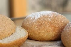 three round breads sitting on top of a wooden table