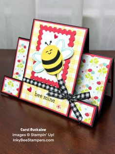 a card with a bee on it sitting on top of a wooden table next to another card