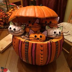 a pumpkin shaped like a basket with three cats in it