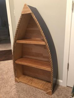 a wooden boat shaped shelf sitting on top of a carpeted floor