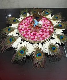 a bowl filled with lots of pink candy and peacock feathers