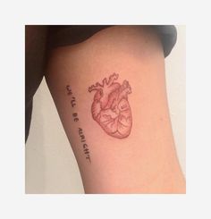 a small heart tattoo on the side of a woman's right leg with words written below it