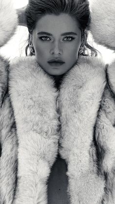 a black and white photo of a woman wearing a fur coat