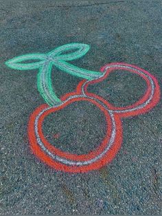 the chalk drawing is on the asphalt and it looks like fruit