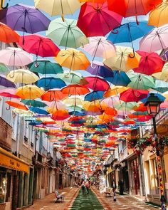 many colorful umbrellas are hanging from the ceiling