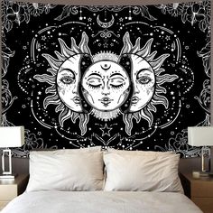 the sun and moon wall hanging above a bed in a room with two lamps on either side