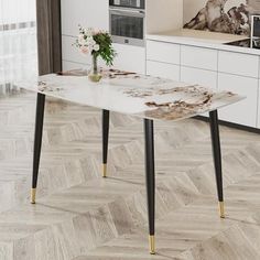 a white table with gold legs in a modern style kitchen and living room area that has wood flooring