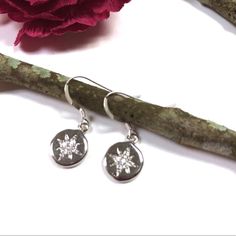 These North Star Earrings Feature Platinum Plated Discs With Sparkly Cz’s And Hang Off Of Sterling Silver Ear Wires Which Are Great For Those With Sensitive Ears. They Come To You In A Lovely Gift Box And Ready For Gift Giving. Tags: North Star, Star, Celestial, Christmas, Birthday, Anniversary, Boho, Graduation, Polaris, Minimalist, Hippie, Star And Moon, Chic Celestial Star-shaped Sparkling Earrings, Sparkling Star-shaped Celestial Earrings, Sparkling Star-shaped Crystal Earrings, Silver Star-shaped Cubic Zirconia Earrings, Elegant Round Earrings With Star Charm, Dainty Round Earrings With Star Charm, Round Star Charm Earrings, Round Star Charm Earrings For Gift, Star-shaped Cubic Zirconia Earrings With Star Charm