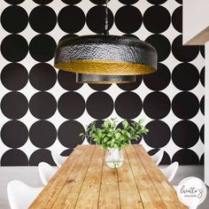 a wooden table sitting in front of a black and white wall