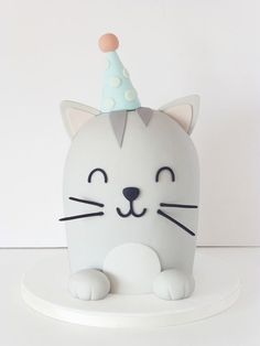 a white cat with a party hat on it's head