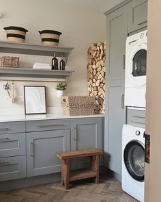 a washer and dryer in a small room with wood stacked on the wall