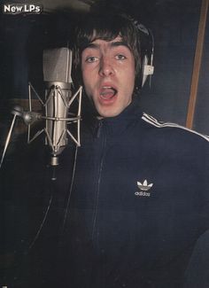 a man with headphones on in front of a microphone, making a surprised face