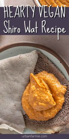 a bowl filled with hummus and sauce on top of a cloth next to some pita bread