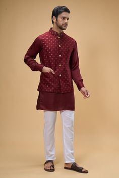 Maroon sleeveless bundi crafted in dupion silk with sequin-thread bloom quad embroidery. Paired with a solid maroon kurta and a white pant. - Aza Fashions Fitted Chanderi Nehru Jacket For Festive Occasions, Festive Fitted Chanderi Nehru Jacket, Fitted Chanderi Nehru Jacket Straight Kurta, Navratri Art Silk Fitted Nehru Jacket, Fitted Silk Nehru Jacket For Transitional Season, Fitted Chanderi Nehru Jacket For Eid, Fitted Chanderi Nehru Jacket For Festivals, Fitted Nehru Jacket With Gota Work For Navratri, Fitted Cotton Nehru Jacket With Gota Work