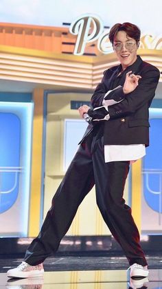 a man in a suit and glasses dancing on stage