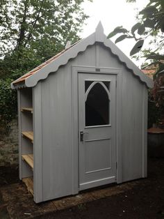 a gray shed sitting in the middle of a yard