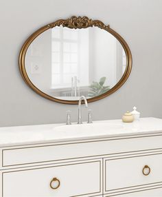 a bathroom vanity with a round mirror above it