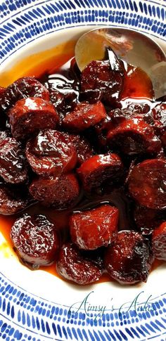 a bowl filled with cooked plums on top of a blue and white table cloth