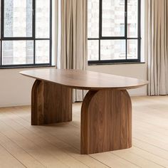 an image of a wooden table in the middle of a room with windows and curtains